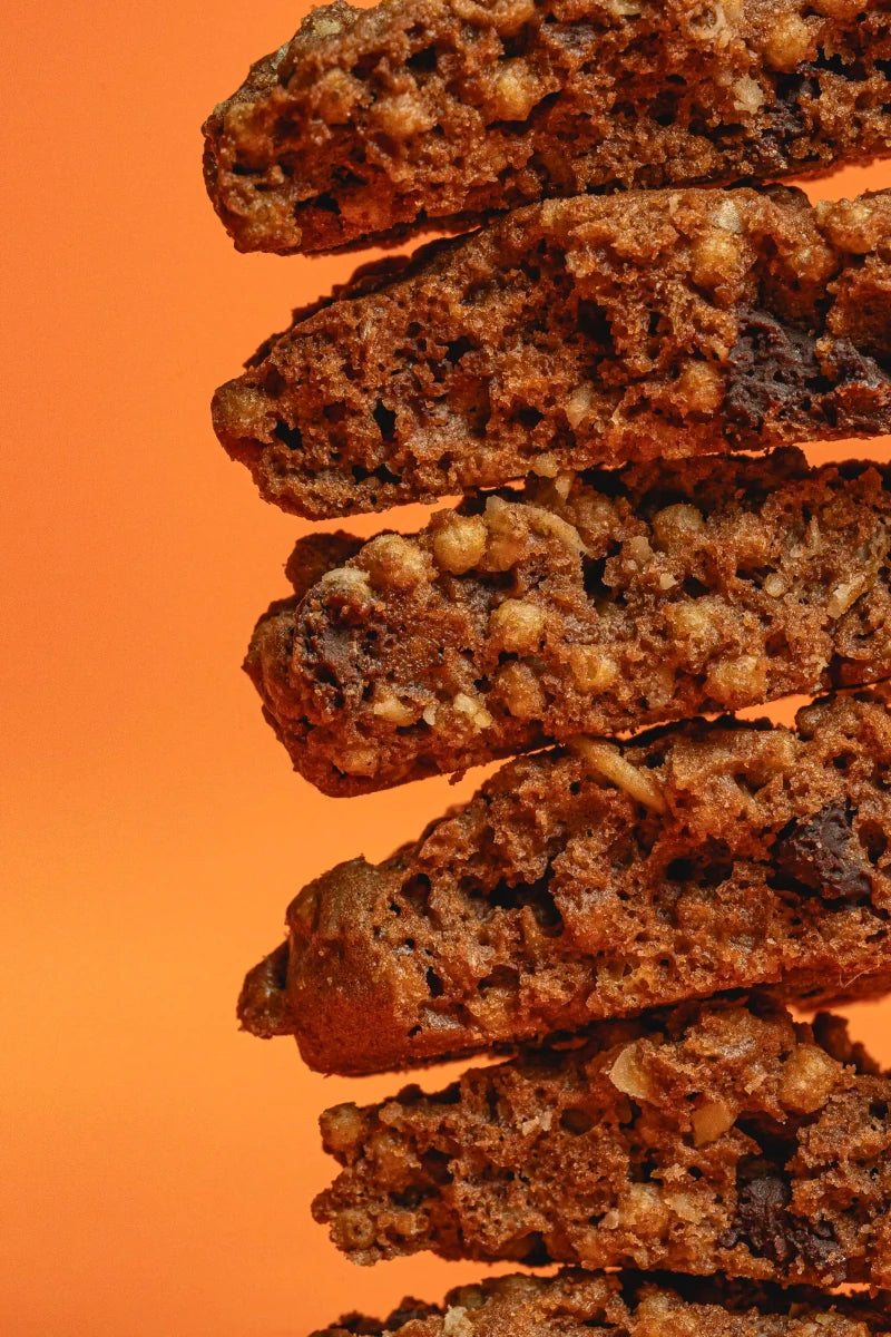 Biscotto artigianale Crunchy Cookie con farro e cacao. Prodotto sfuso, spezzato a metà per far vedere la texture dell'interno.