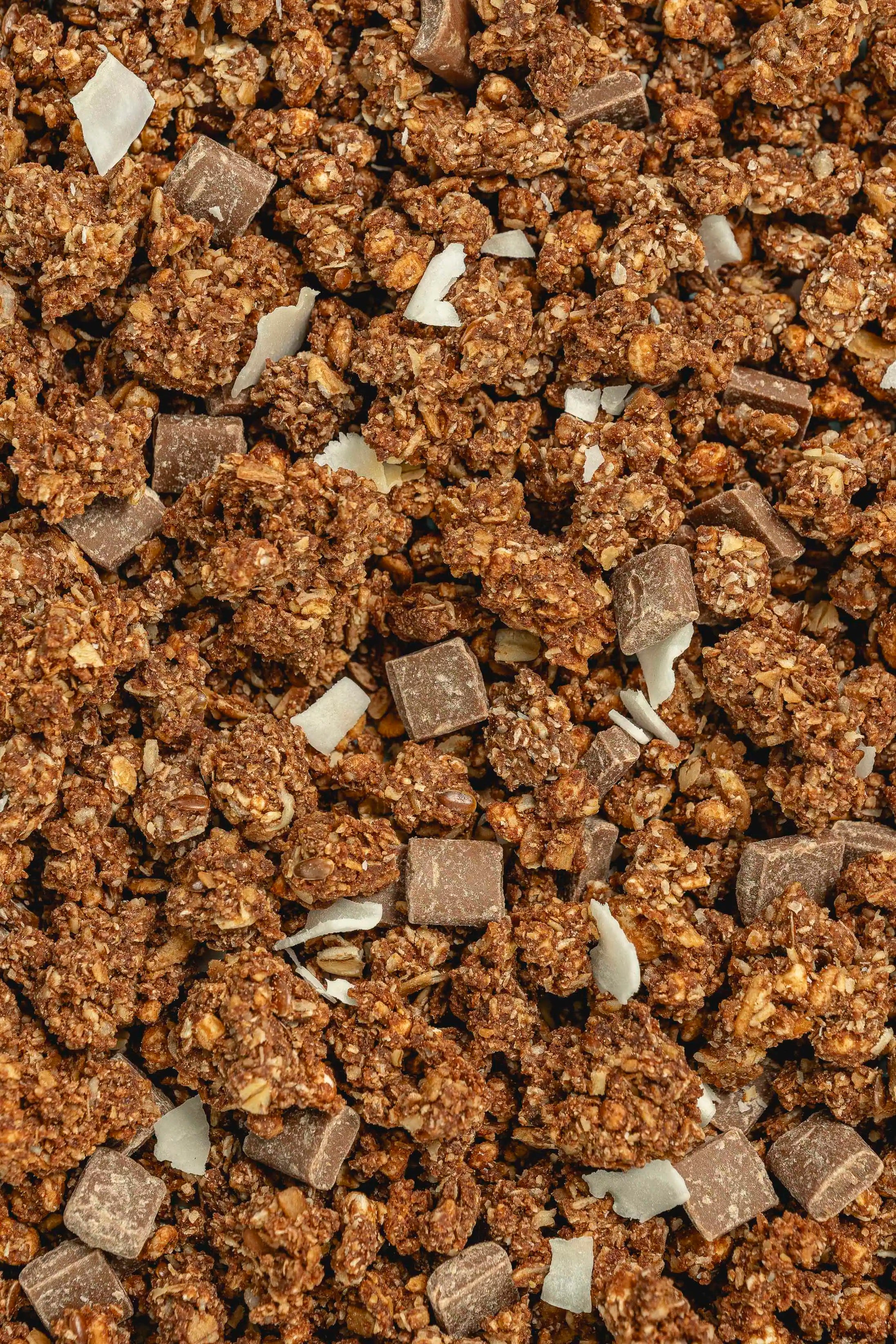 Texture della granola artigianale al farro Poggio del Farro, ingredienti visibili (cioccolato al latte e cocco) e tostatura in teglia